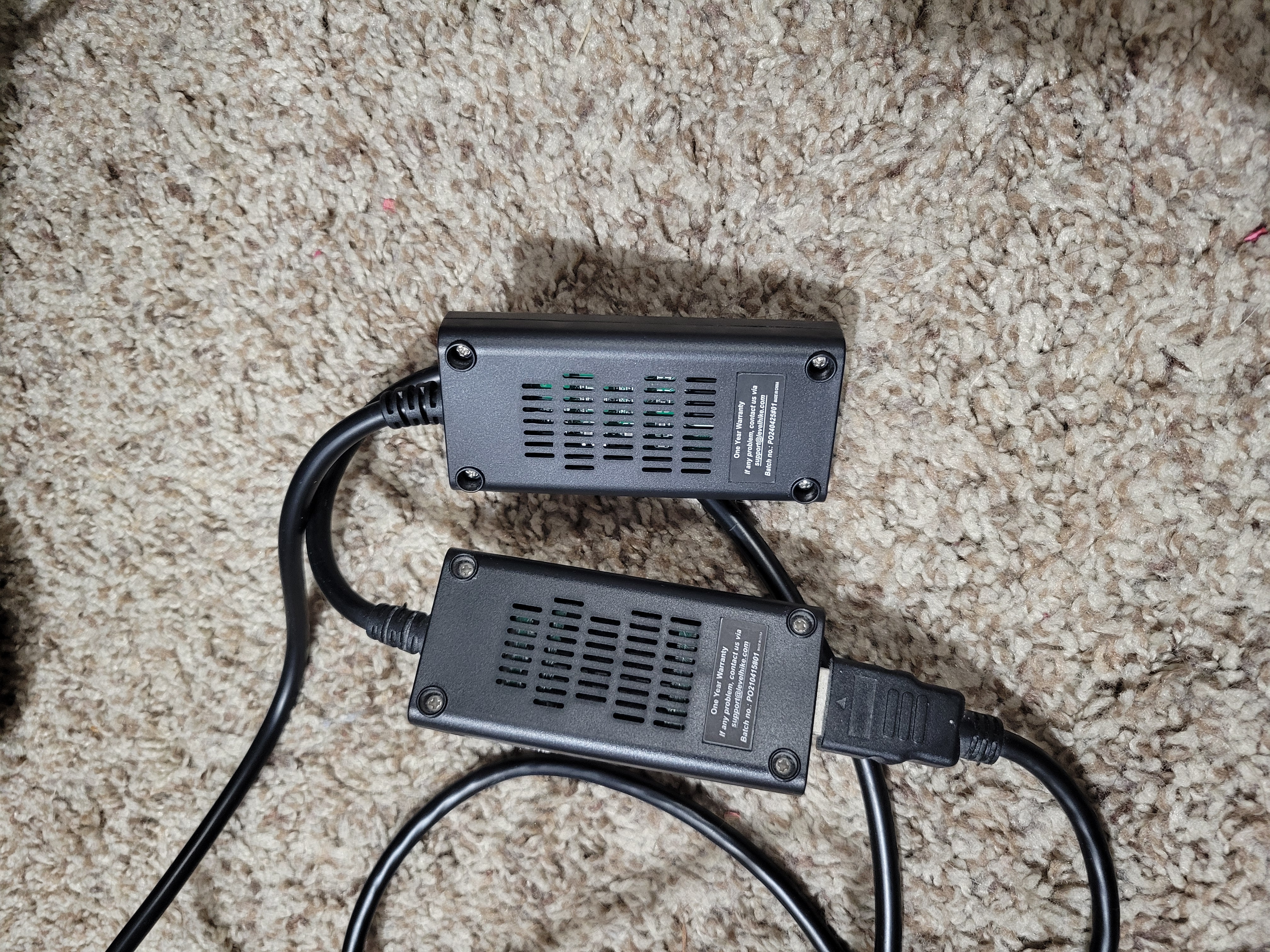 Two black boxes side to side with cords sticking out.